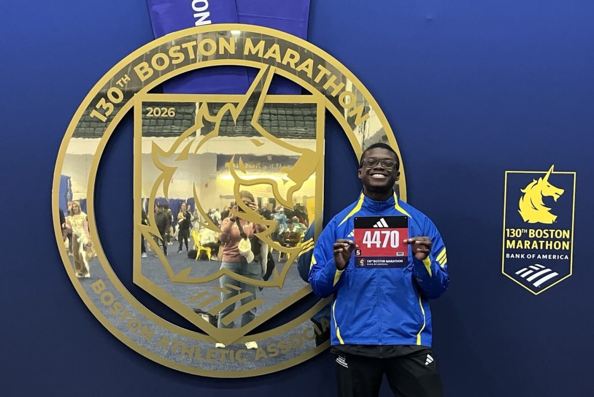 Simeon Omorodion celebrates with medal at Boston Marathon finish line