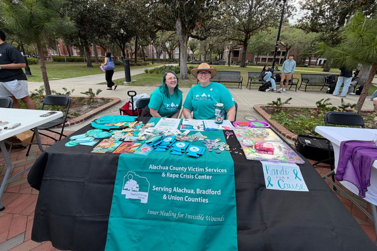 Volunteers at outreach table sharing violence prevention resources and support information at community event