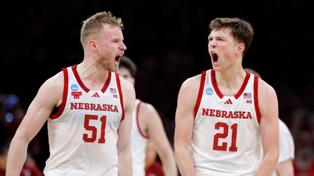 Nebraska basketball players celebrating together on court after first NCAA tournament victory