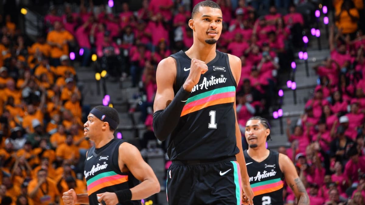 Victor Wembanyama dunking basketball in orange shoes during San Antonio Spurs playoff game