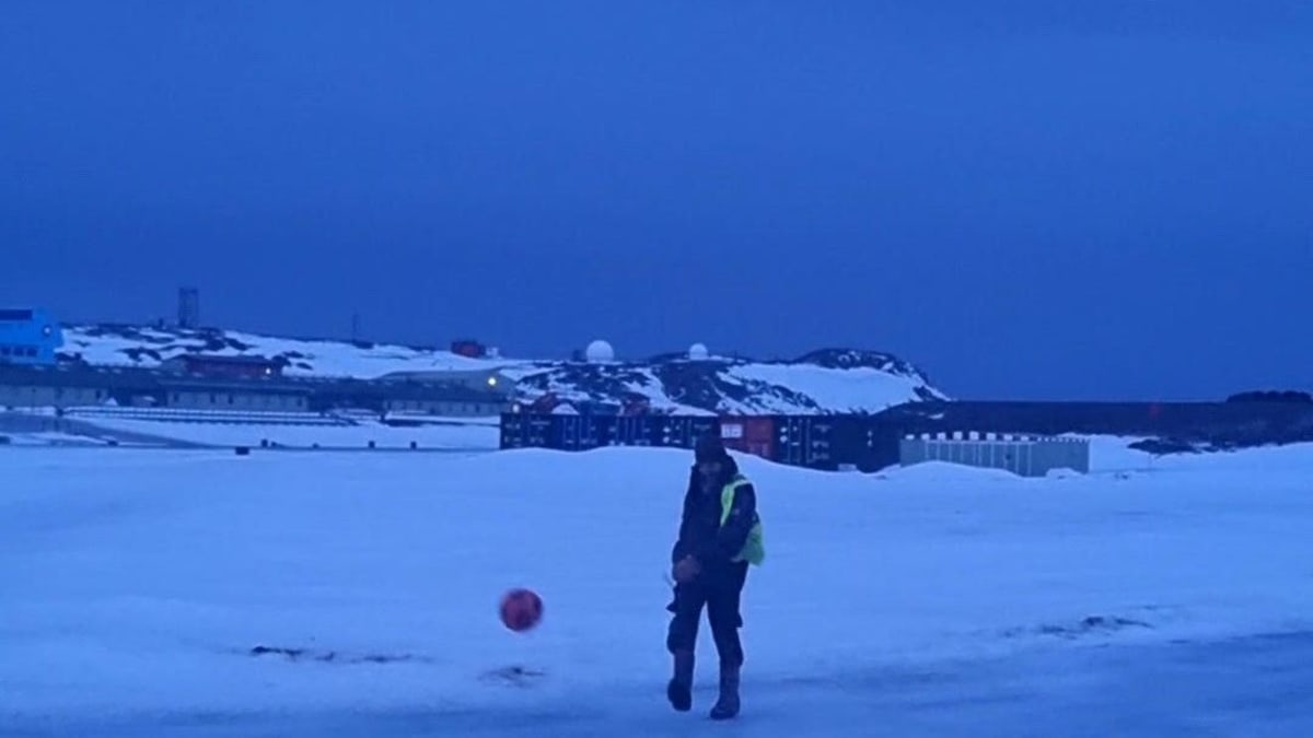 Antarctic research station at night with people gathered around screen watching football match together