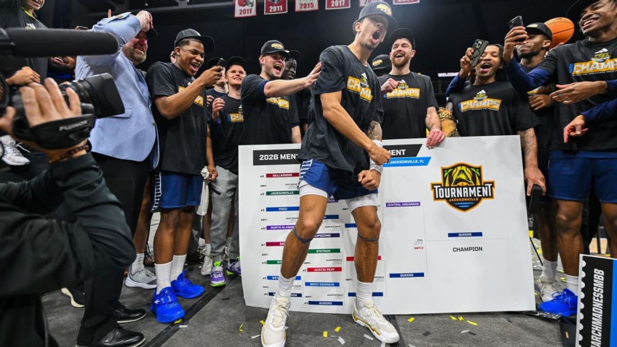 Queens University basketball player Chris Ashby celebrates tournament championship victory with teammates