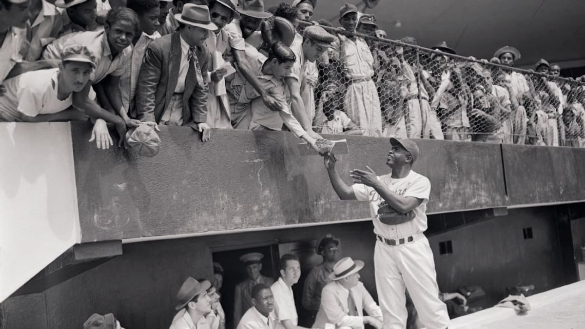 Jackie Robinson in Brooklyn Dodgers uniform number 42 standing on baseball field in 1947