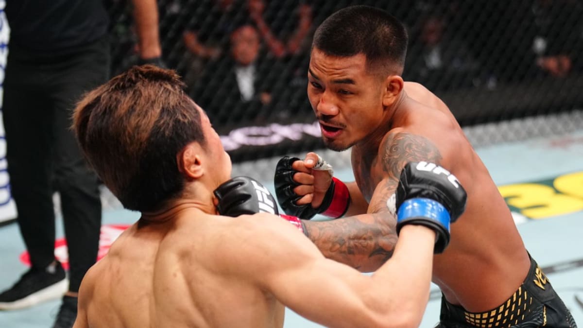 Joshua Van celebrates championship victory inside UFC octagon after fifth round stoppage win