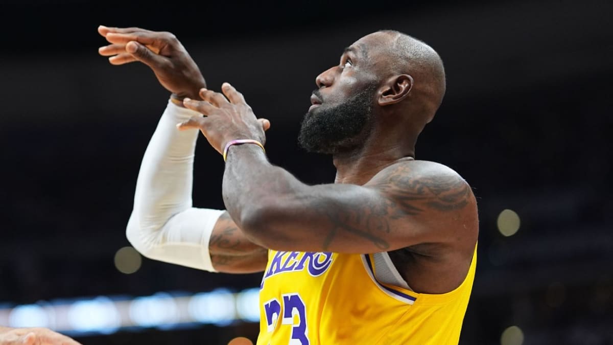 LeBron James in Lakers uniform shooting turnaround baseline jump shot against Denver defender