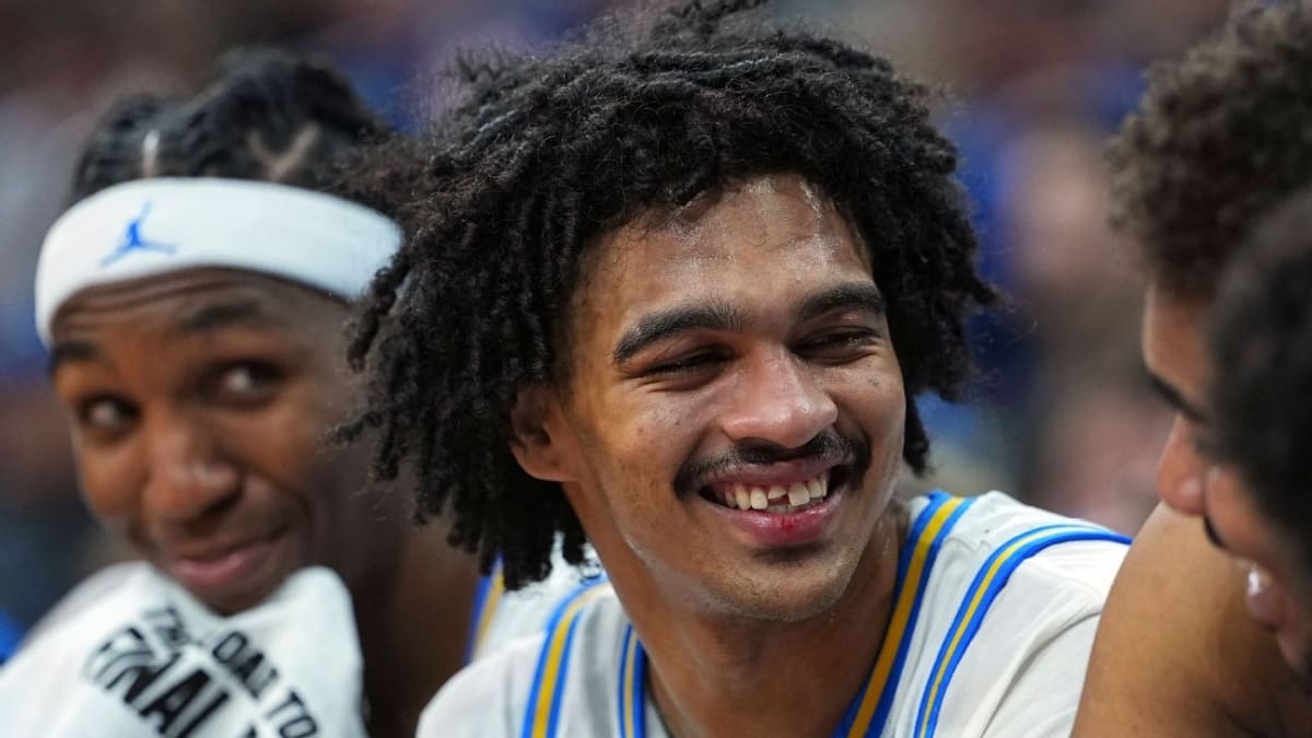 UCLA basketball player Skyy Clark smiling in locker room showing gap where tooth was lost