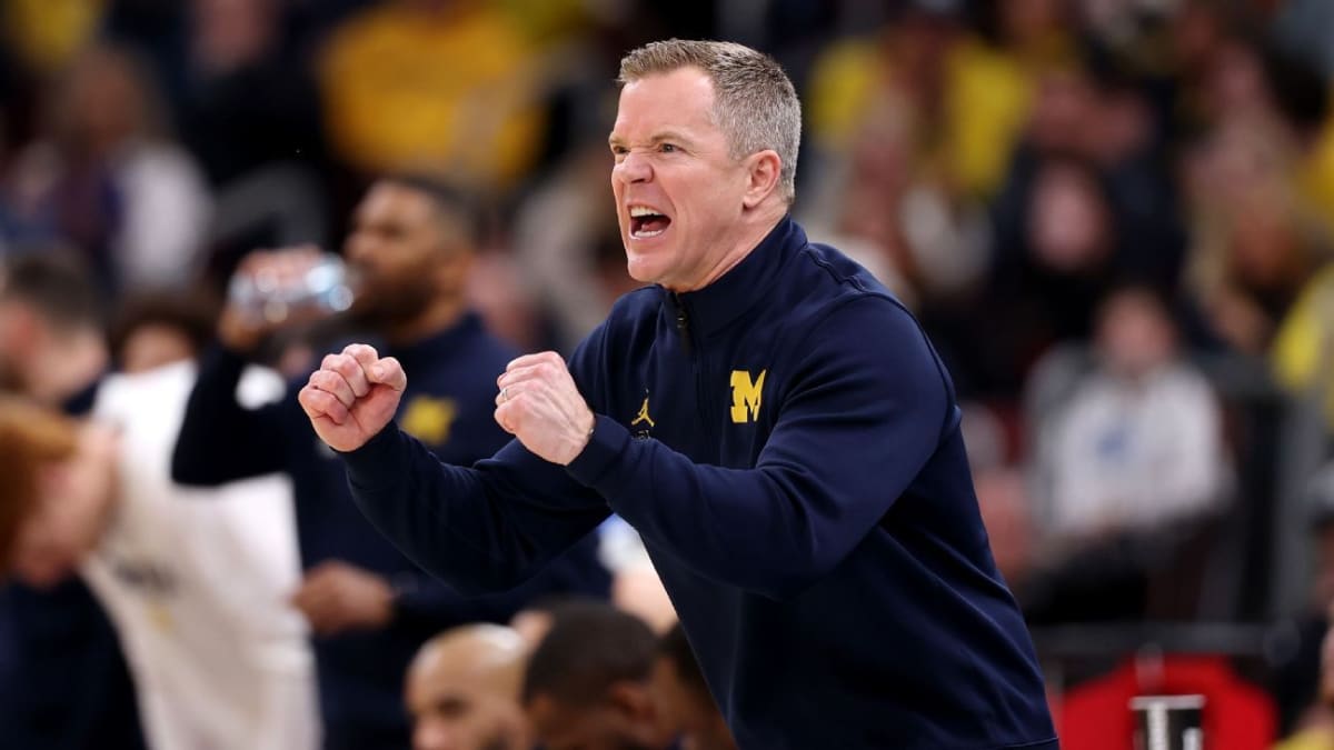 Michigan basketball coach Dusty May celebrating with players during Final Four tournament game