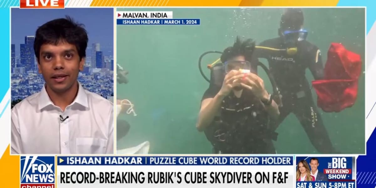 Puzzle champion Ishaan Hadkar solving Rubik's Cubes during skydive over California coast