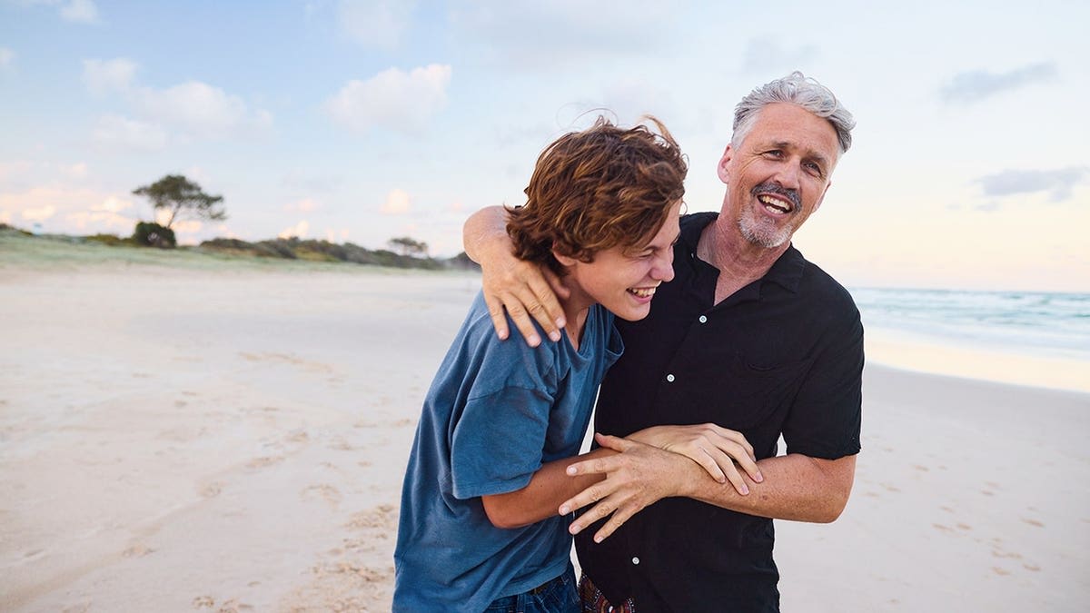 Father and child laughing together while sharing jokes at home