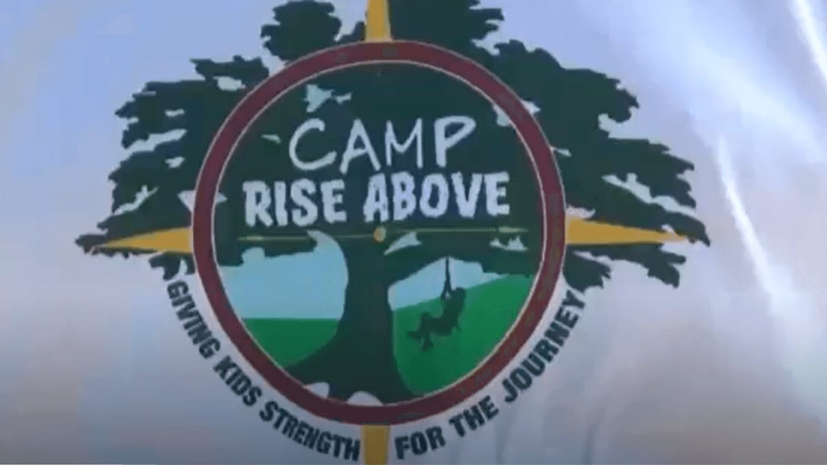 Camp Rise Above logo displayed on news broadcast screen in Charleston studio