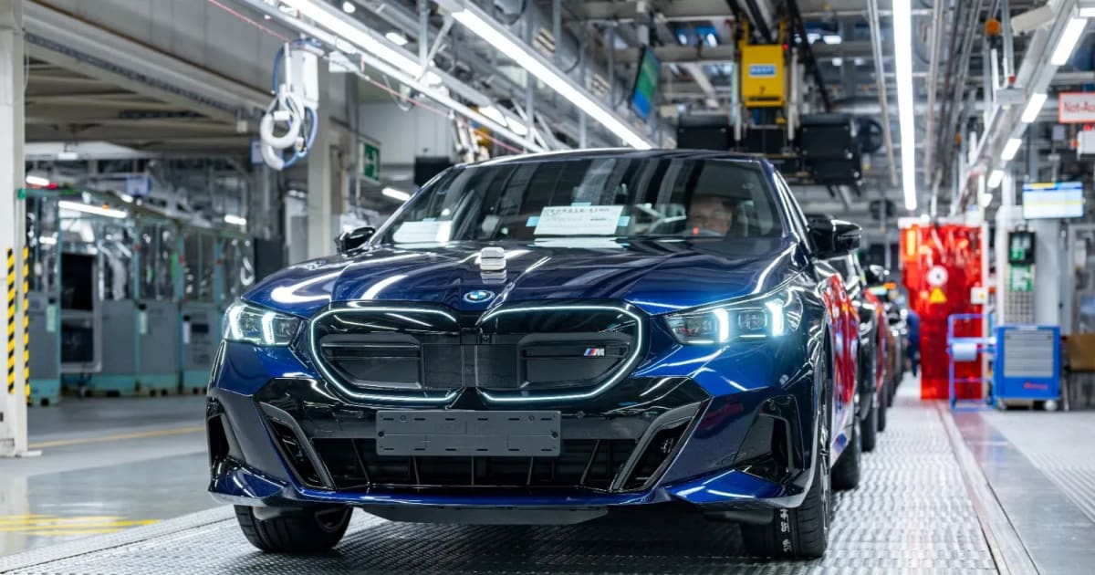 Blue BMW i5 electric sedan on manufacturing assembly line at German factory