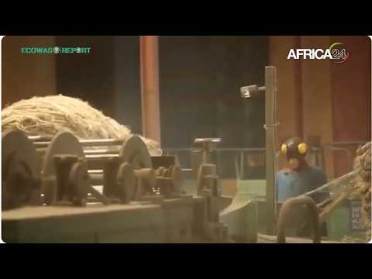 Workers in modern packaging facility handling industrial materials in West African manufacturing plant