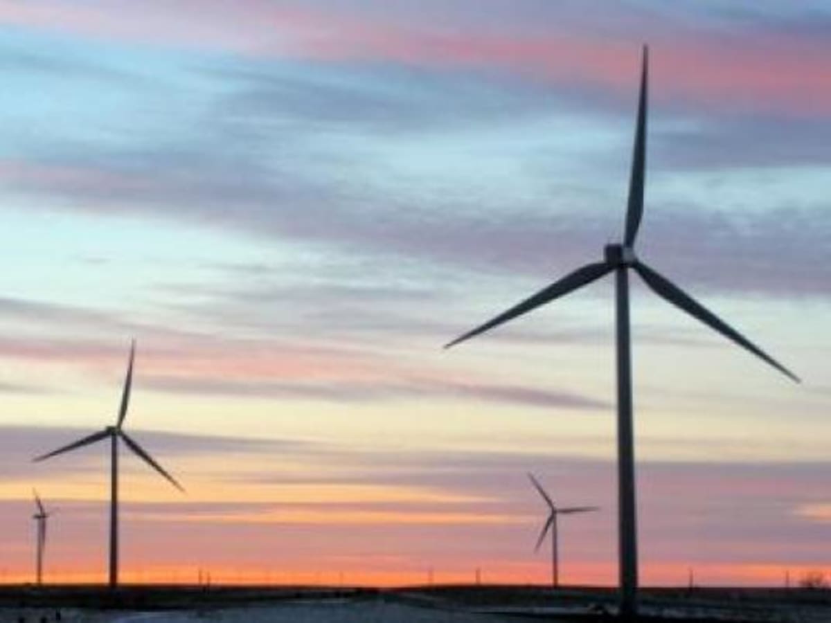 Wind turbines standing tall against blue sky near Egypt's Gulf of Suez coastline