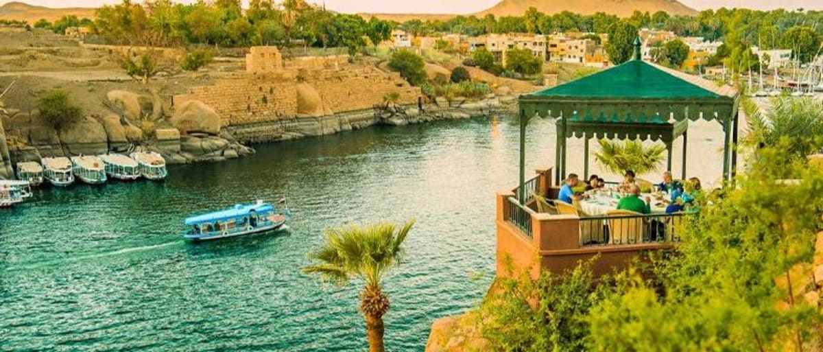 Tourists visiting ancient Egyptian temple ruins along the Nile River in Aswan