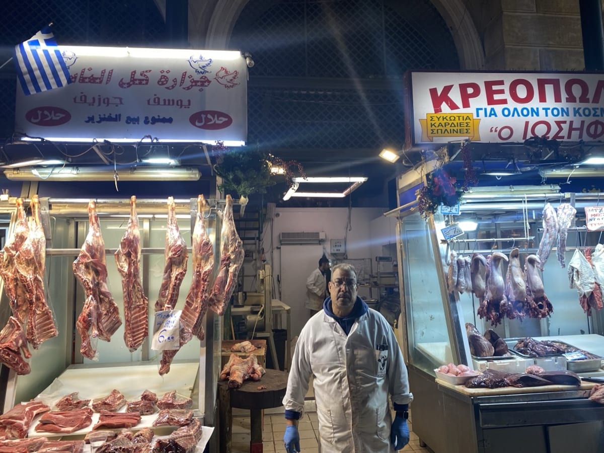 Egyptian butcher Youssef Basta standing proudly behind his meat counter in Athens Central Market