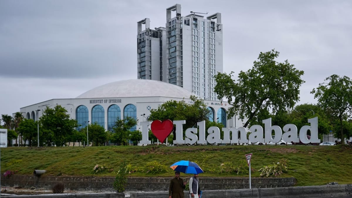 Diplomatic officials walking through secure barriers in Islamabad, Pakistan during historic peace negotiations