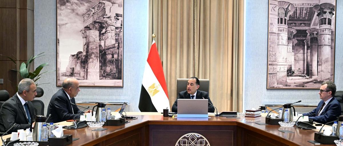 Solar panels and wind turbines stretching across Egyptian desert landscape under bright blue sky