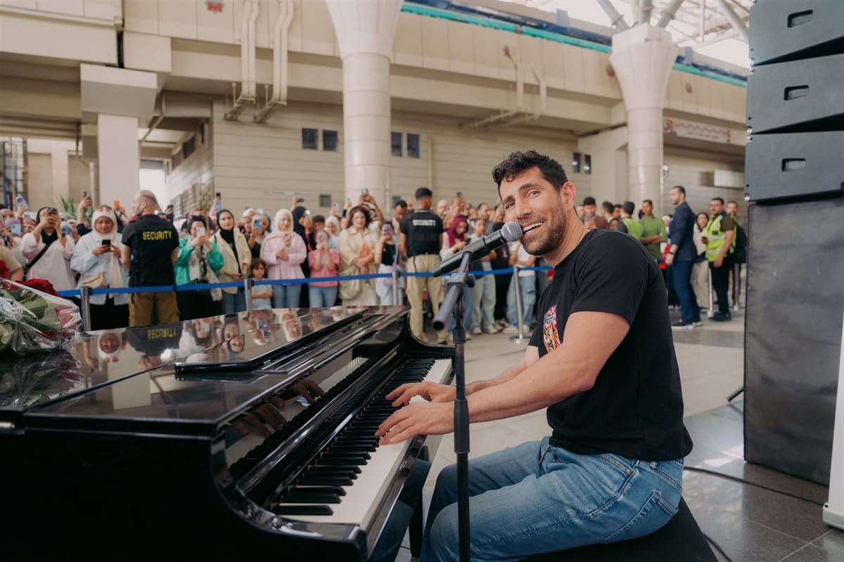 Jordanian musician Aziz Maraka performing with guitar for surprised commuters at Cairo metro station
