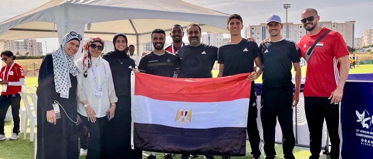 Two teenage Egyptian archers celebrating with gold medals at African championship competition