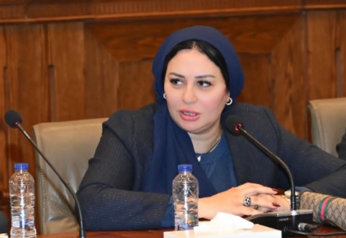 Egyptian woman holding national identification card, symbolizing official recognition of motherhood and caregiving