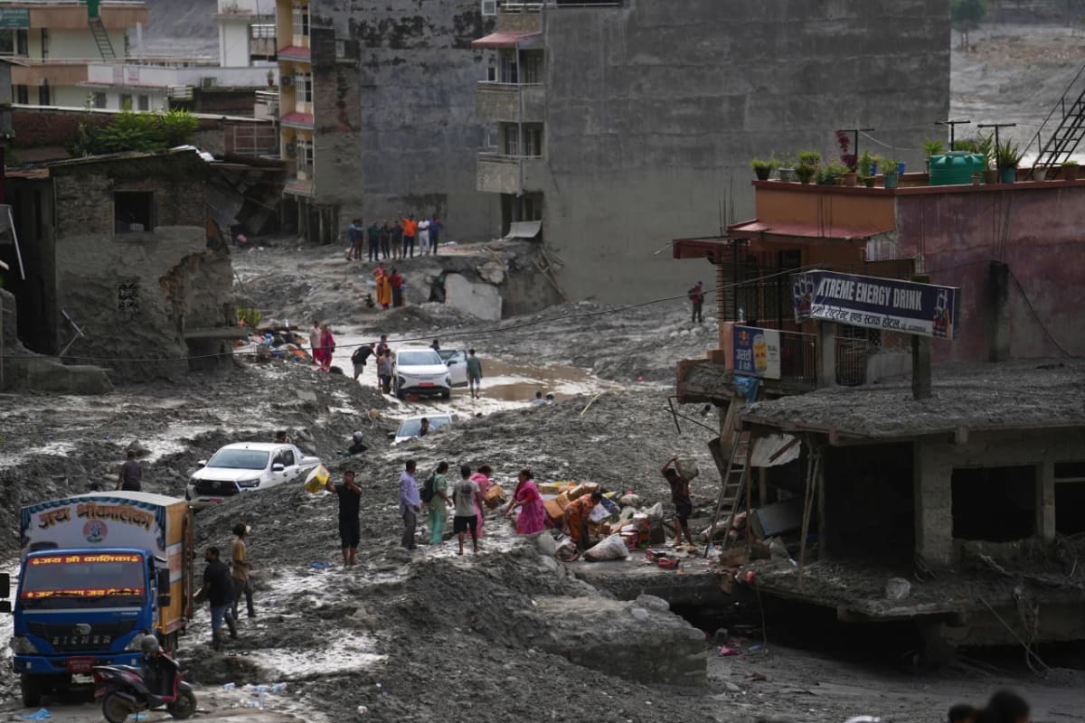 Nepali families salvaging belongings from flood-damaged building in Nuwakot district