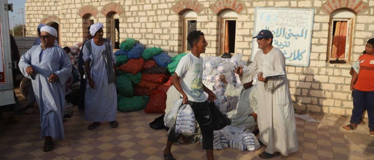 Food aid convoy trucks delivering emergency supplies to families in rural Egyptian village