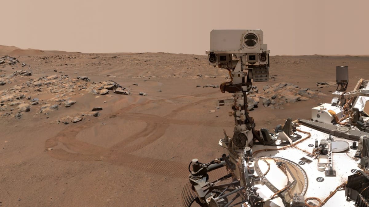 ** NASA's Perseverance rover exploring the red dusty surface of Mars beneath clear sky