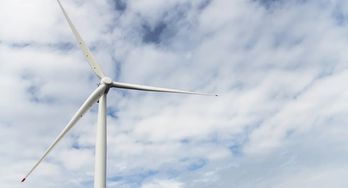 Wind turbines and solar panels against blue sky in New York renewable energy project