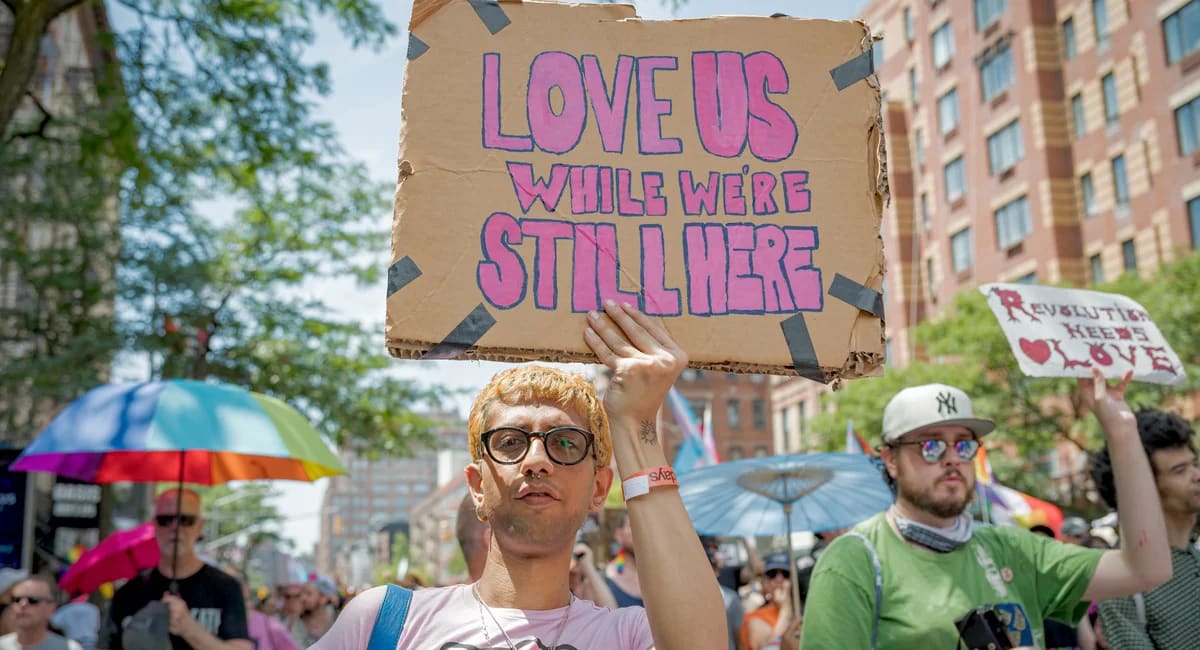 ** Colorful crowd of people celebrating at NYC Pride March with rainbow flags waving