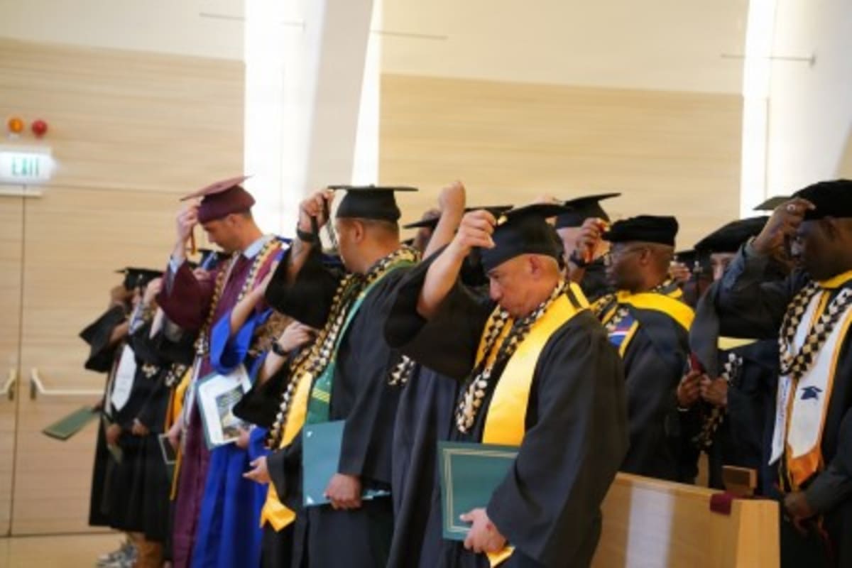 Military graduates in caps and gowns at ceremony in Netzaberg Chapel, Germany
