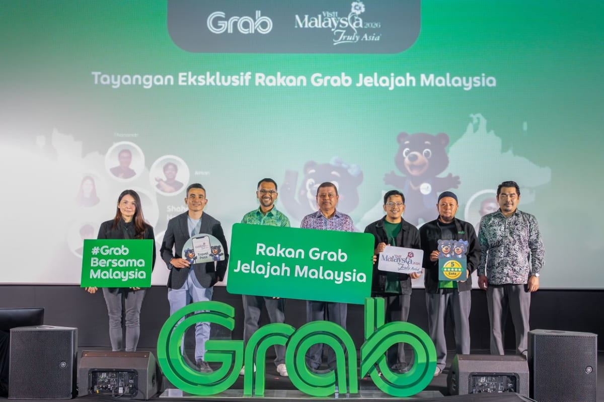 ** Grab Malaysia team and driver partners standing together at Visit Malaysia 2026 launch event