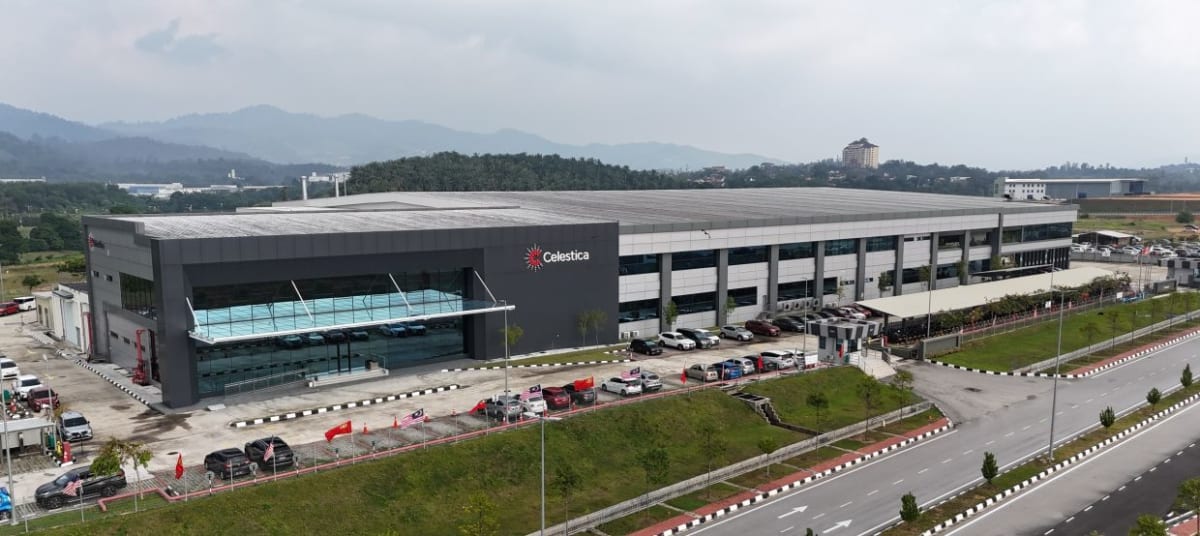Modern technology manufacturing facility in Malaysia with workers collaborating on advanced computing infrastructure