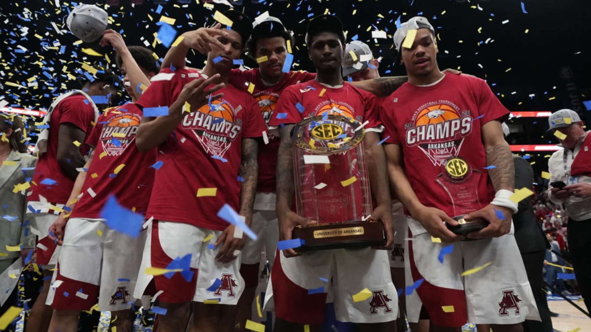 Arkansas Razorbacks players celebrating with SEC Tournament championship trophy in Nashville