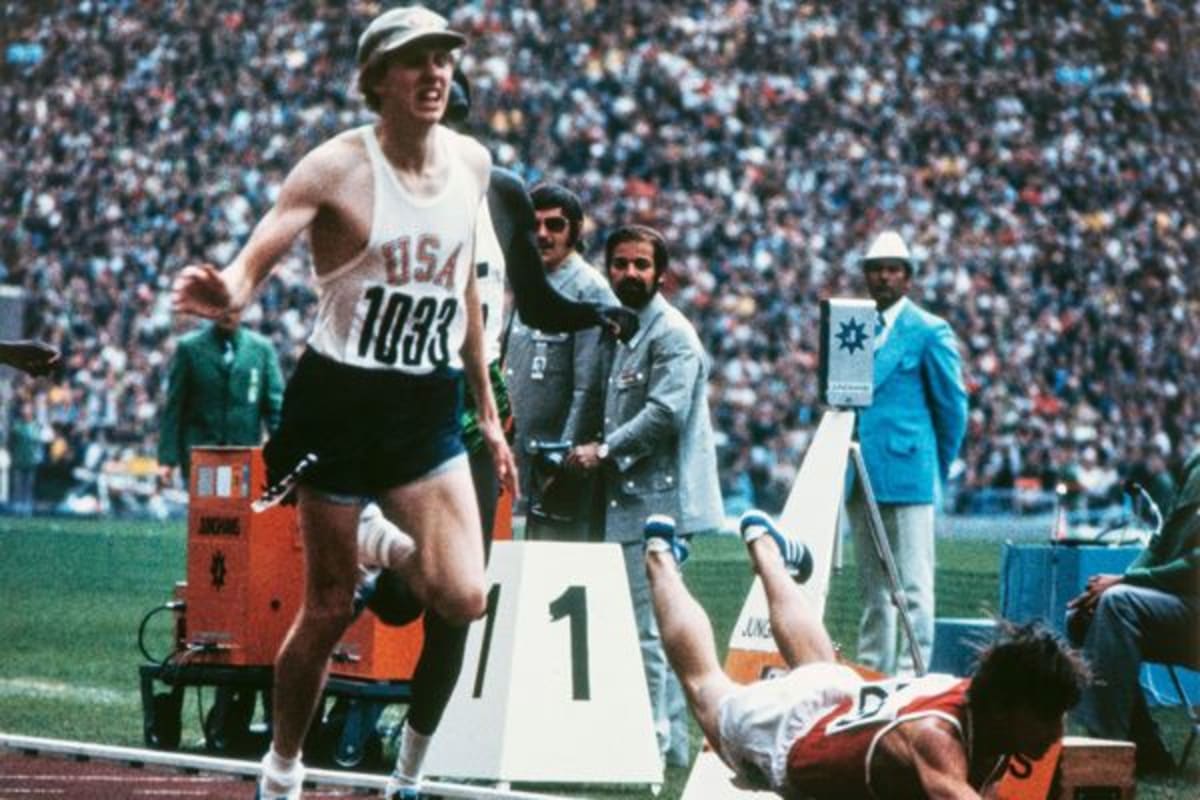 Dave Wottle wearing cream golf cap crosses finish line at 1972 Munich Olympics