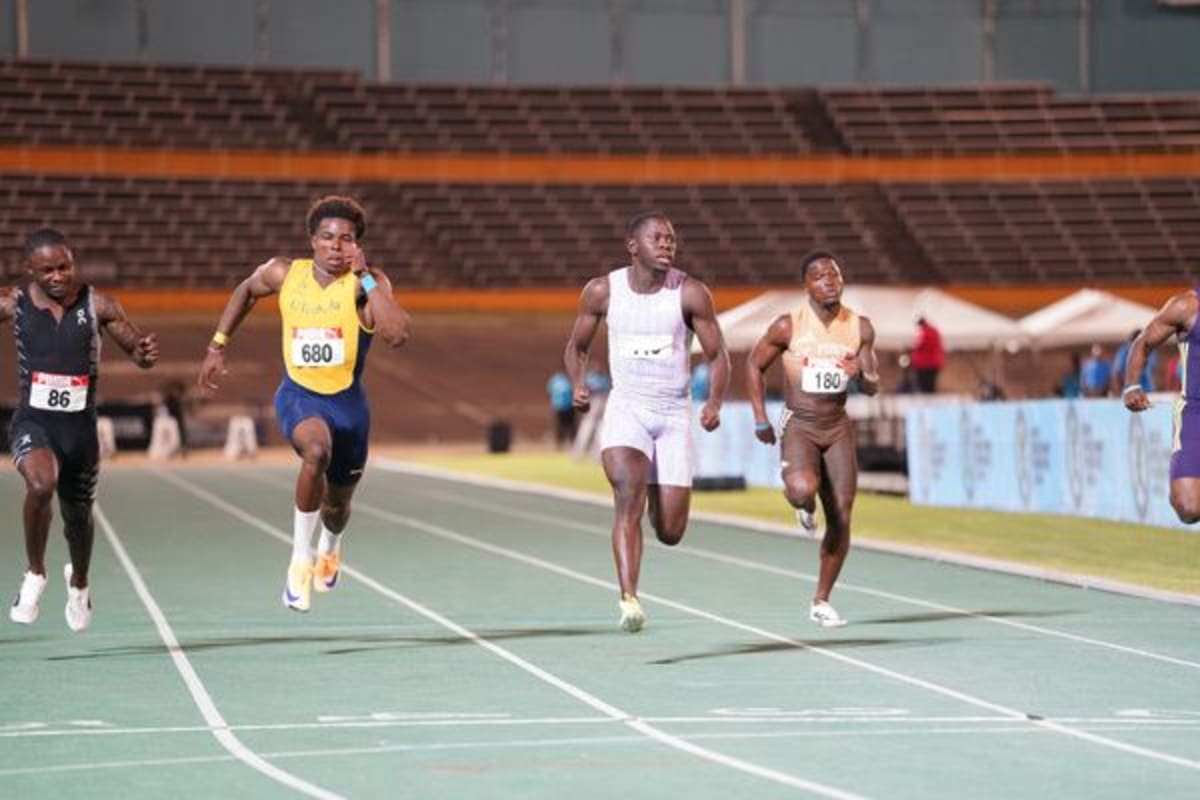 Oblique Seville crossing finish line at Jamaican Championships in Kingston, celebrating victory