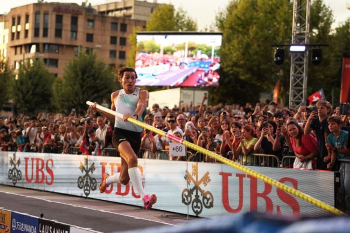 ** Mondo Duplantis mid-vault clearing bar during record-breaking pole vault competition in Lausanne