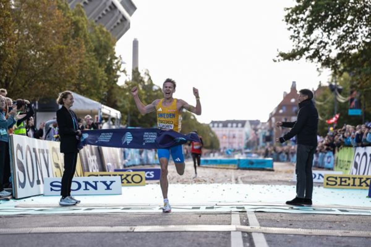 Andreas Almgren crosses finish line celebrating world half marathon championship victory in Copenhagen