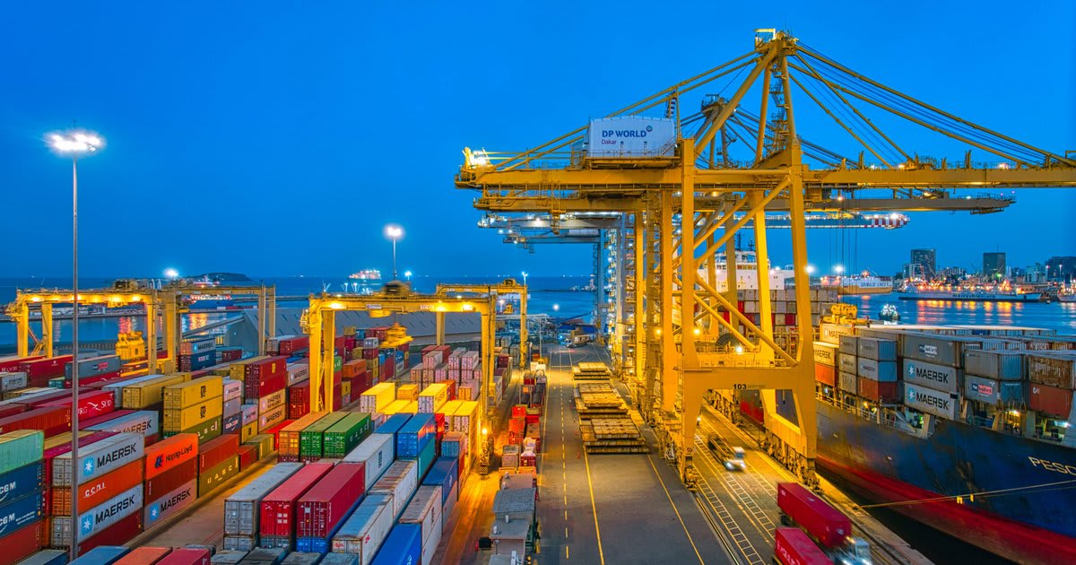 Container ship and trucks representing global logistics operations reducing carbon emissions through technology