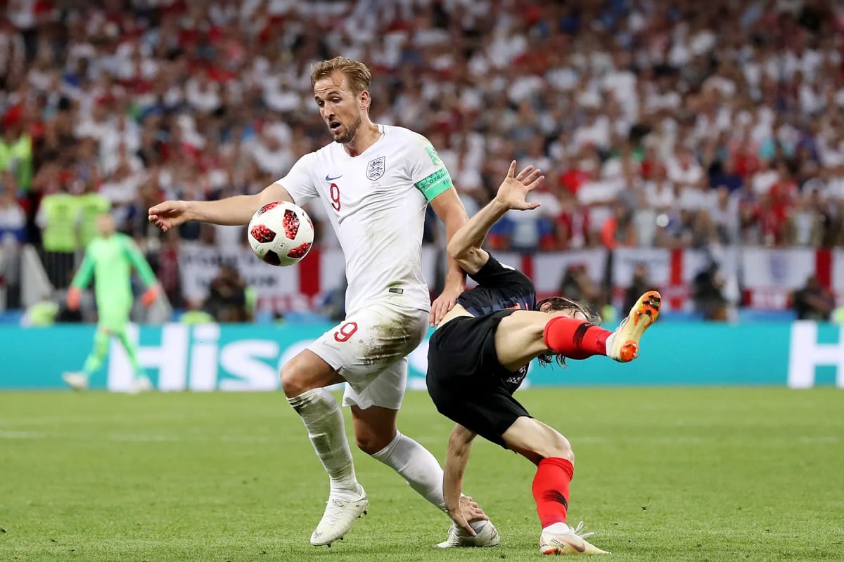 England football fans celebrating together in a crowded pub wearing team jerseys