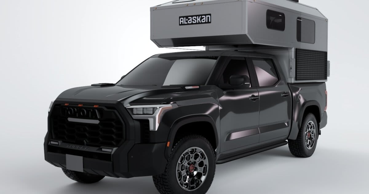 Modern white truck camper with fixed roof and overhead sleeping area parked outdoors