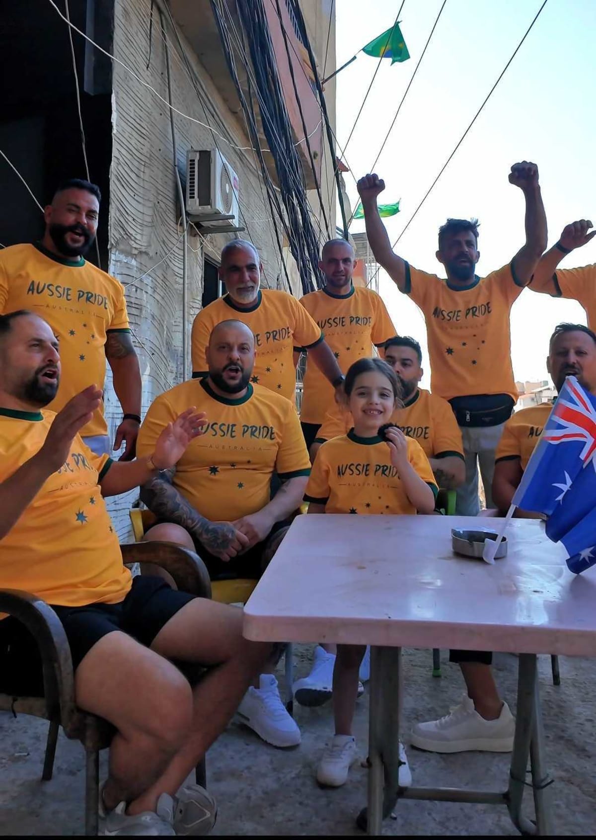 Lebanese Socceroos fans celebrate with Australian flags and green and gold colors in Tripoli street parade