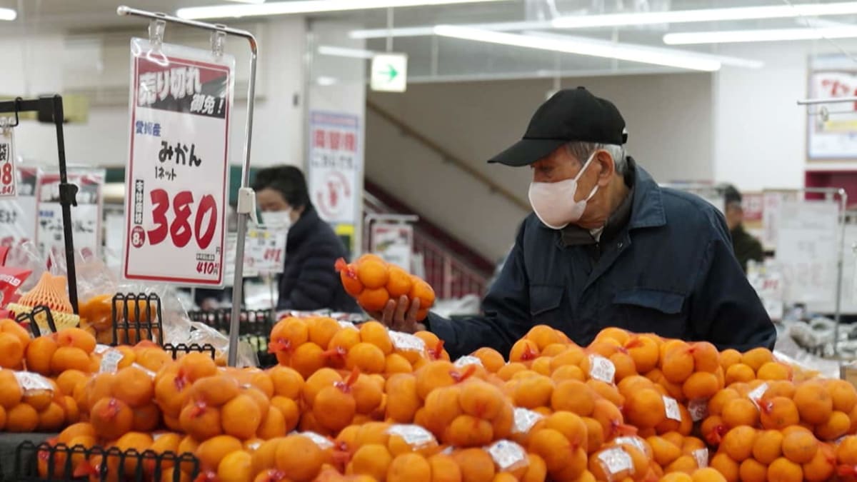 Elderly Japanese man in his seventies volunteering as street cleaner, smiling while working