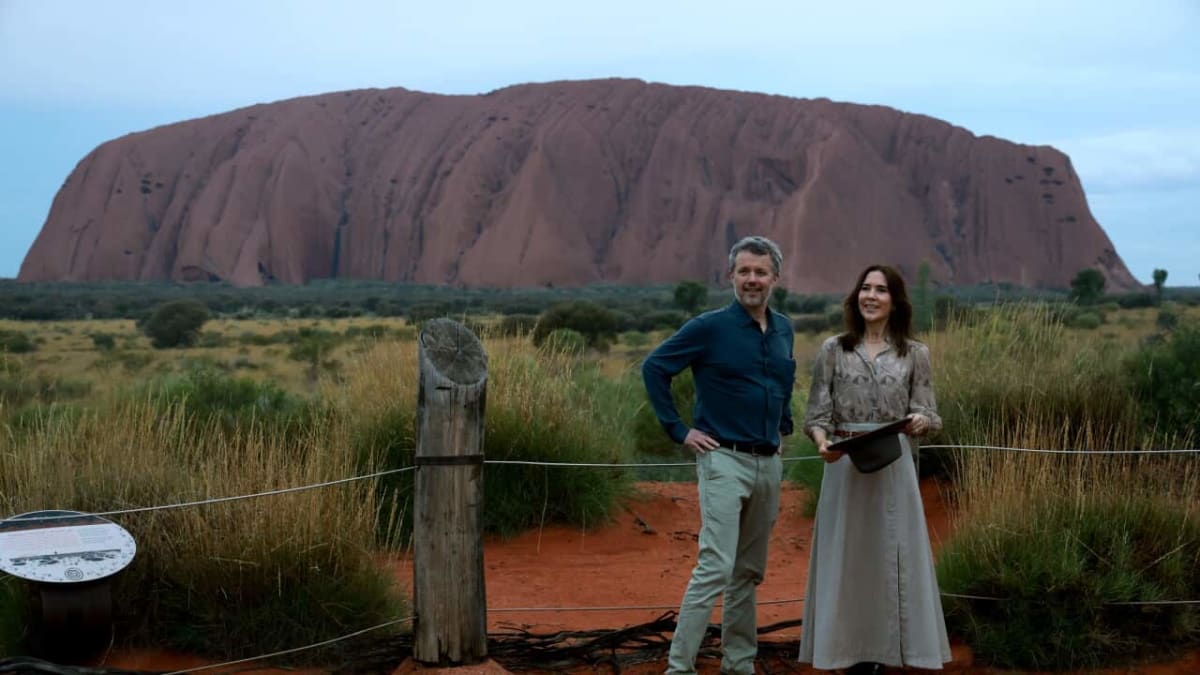 Denmark's King Frederik and Queen Mary walking at sunrise near Uluru's sacred waterhole