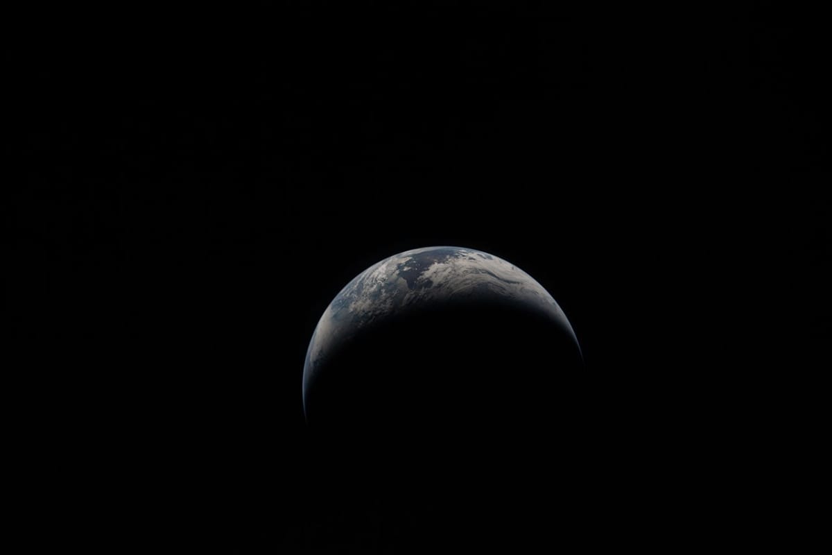 ** Crescent Earth setting below lunar horizon photographed by Artemis II astronauts from Moon orbit