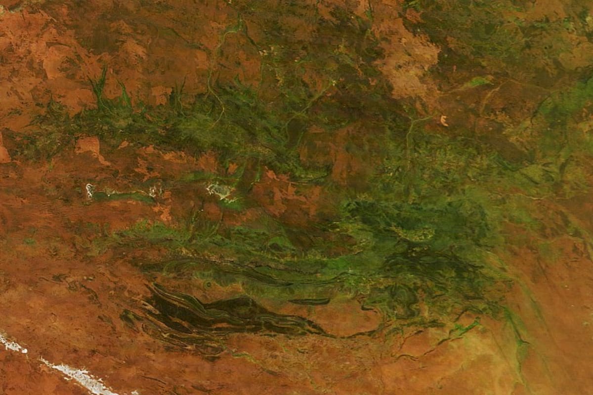 Satellite comparison showing Australia's Red Centre desert transformed from rusty red to lush green vegetation