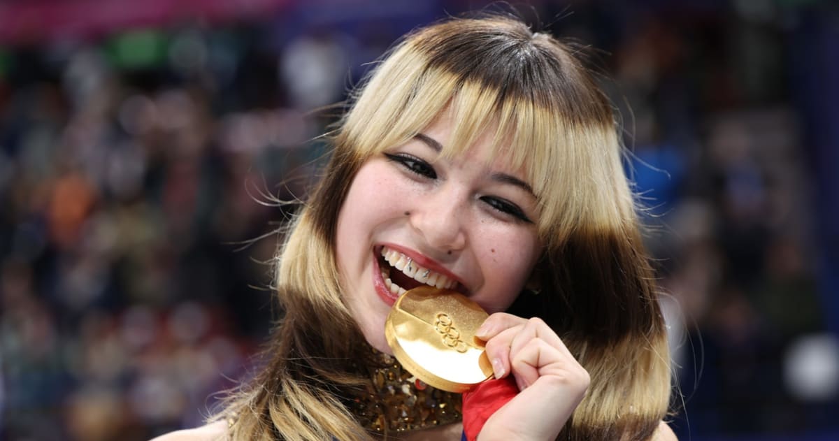Olympic figure skating champion Alysa Liu smiling with two gold medals around her neck