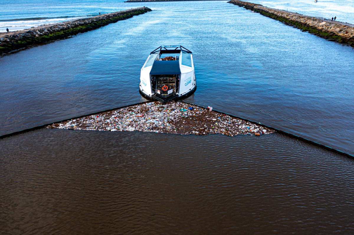 Innovative floating barrier system catching plastic trash in river before reaching ocean