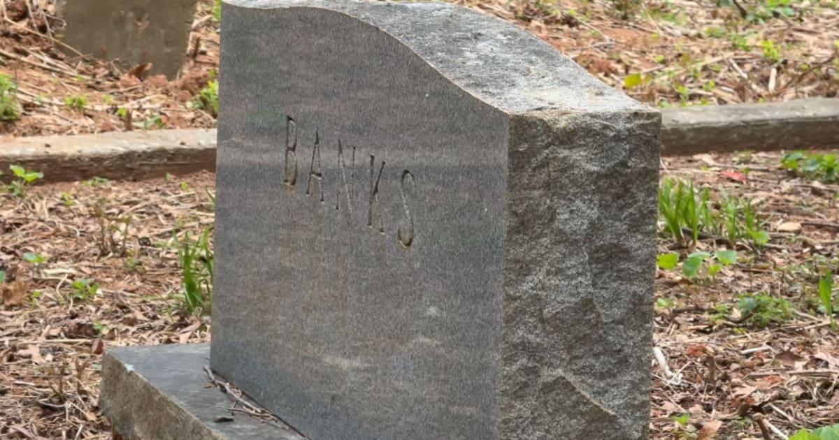 Volunteers clearing overgrown vegetation from historic African American cemetery headstones in College Park Georgia