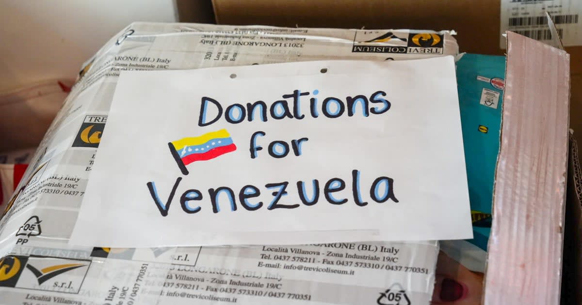 Volunteers in warehouse sorting and packing humanitarian aid boxes for Venezuela relief effort