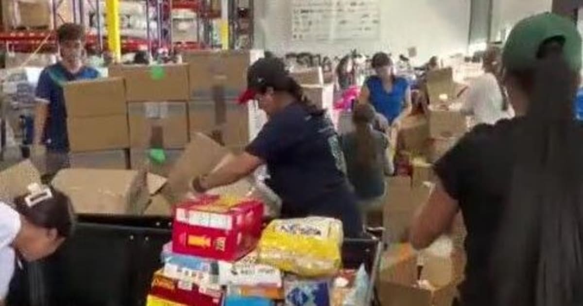 Volunteers sorting donated blankets and supplies inside Global Empowerment Mission warehouse in Doral, Florida